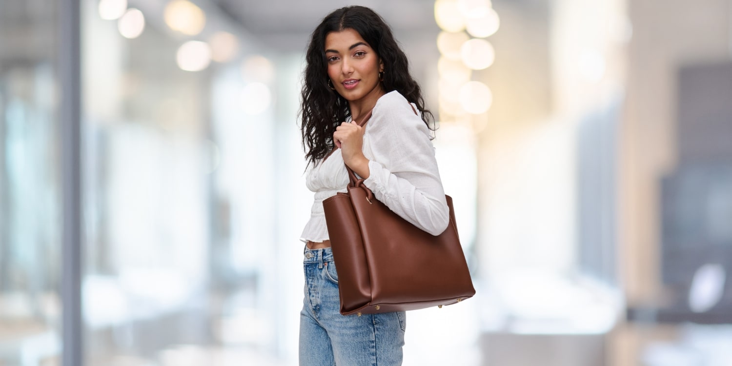 a woman holding a trendy bag for work