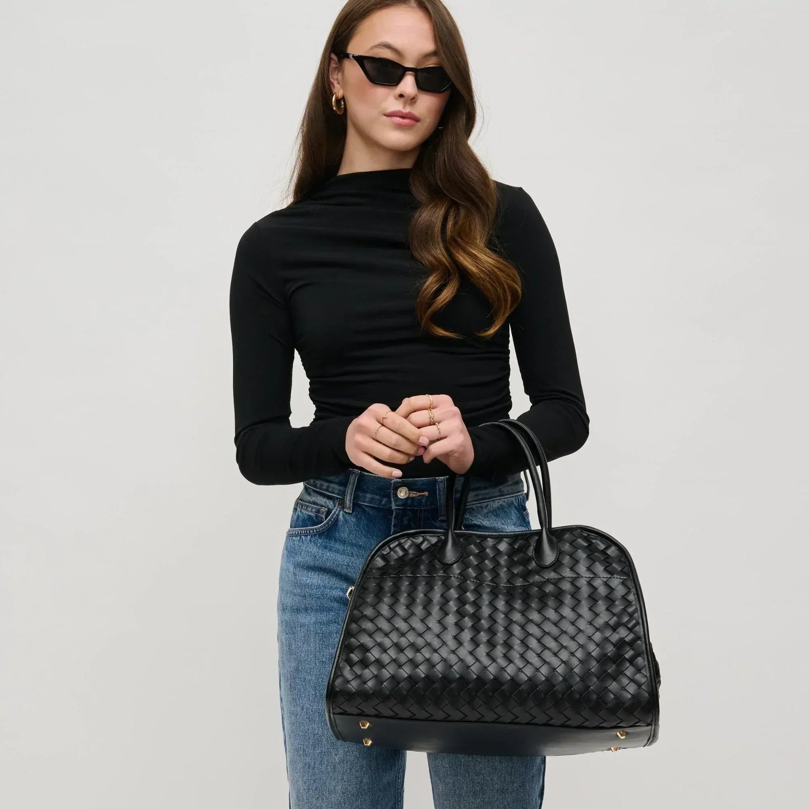 Woman in a 90s minimalism outfit with a woven tote bag