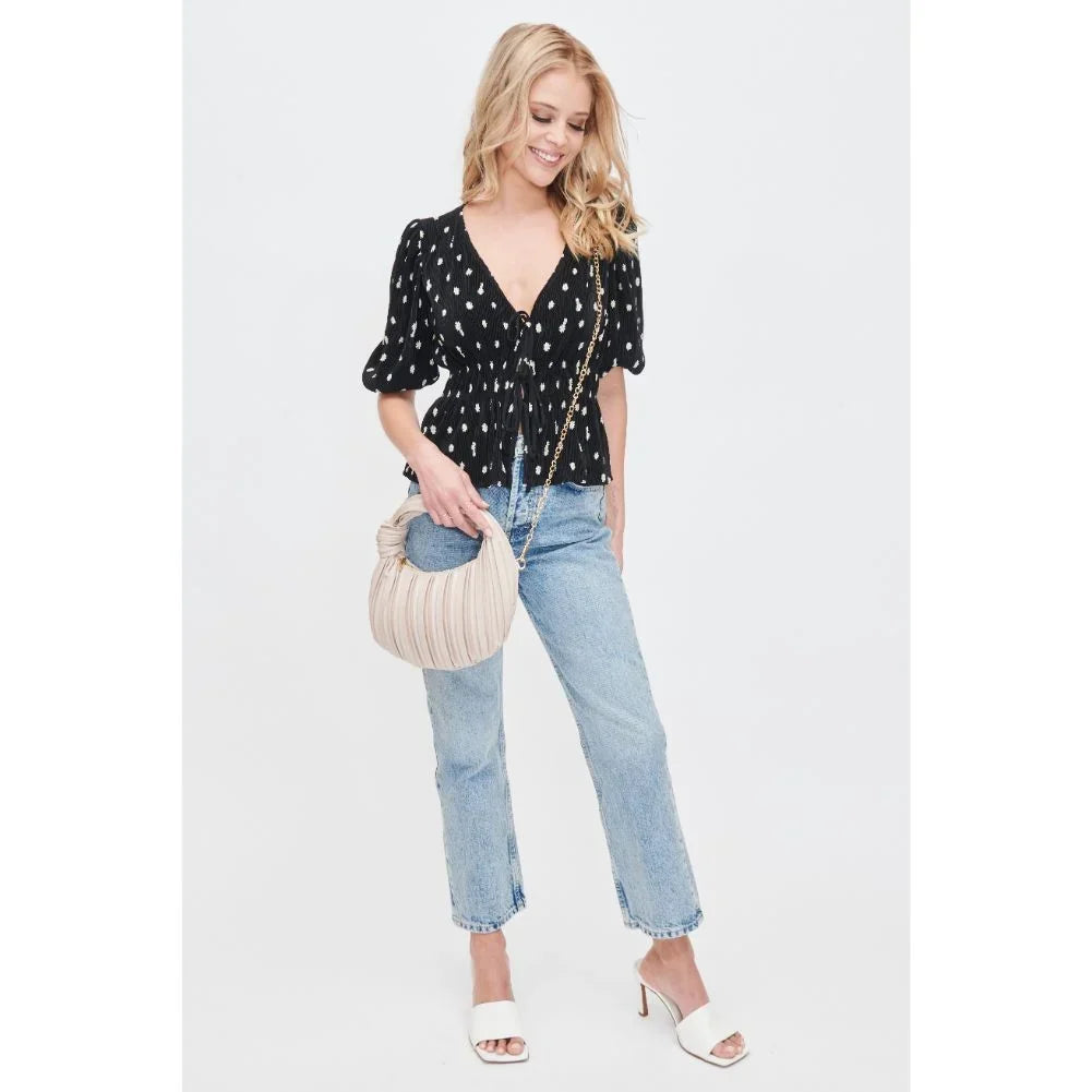 Woman in a casual polka dot outfit holding a handbag